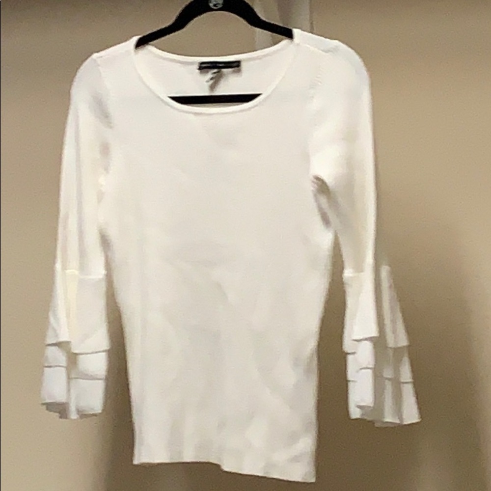 White sweater with bell sleeves.
